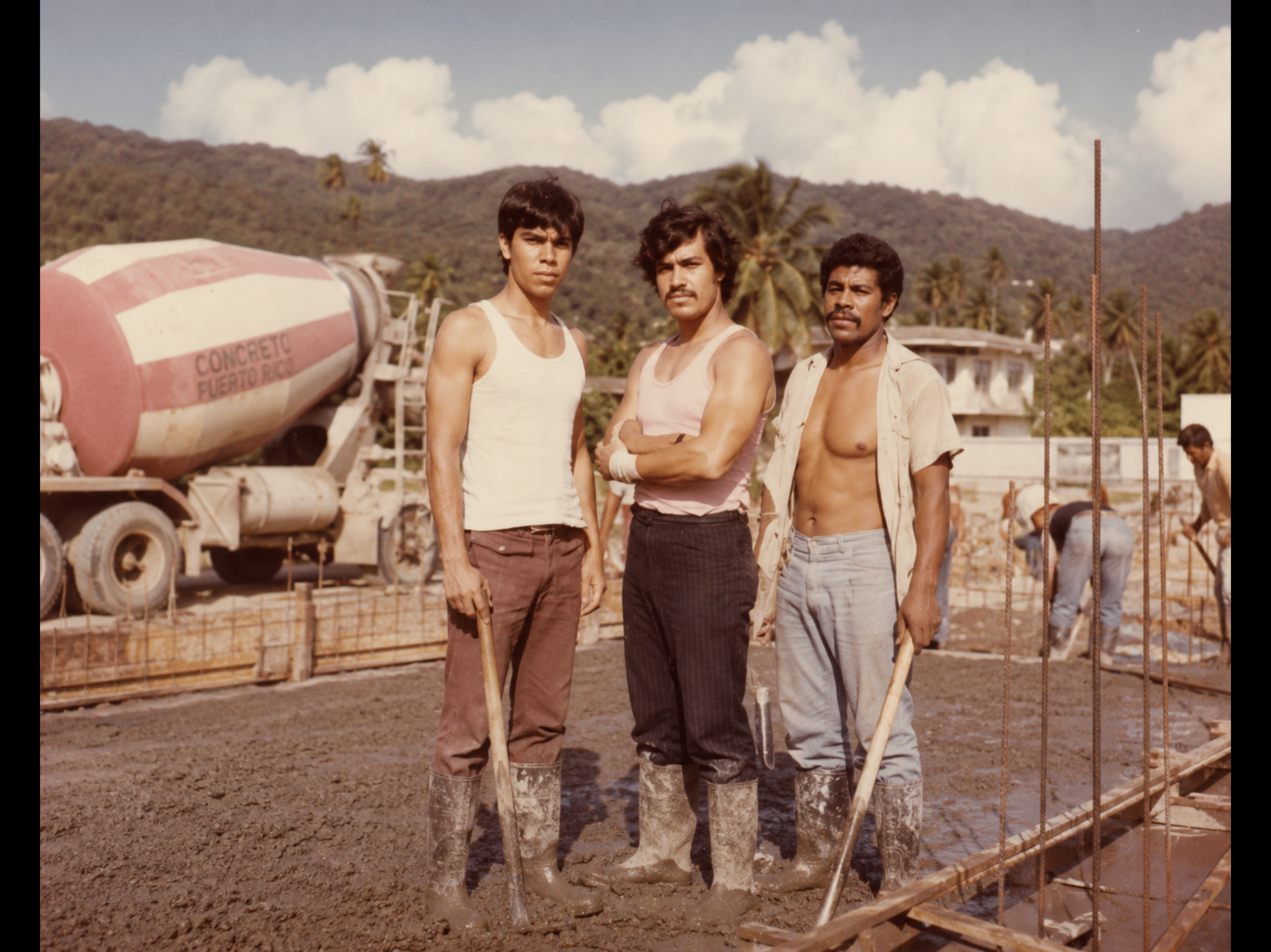 Concrete crew standing on a fresh deck beside a Concreto Puerto Rico mixer